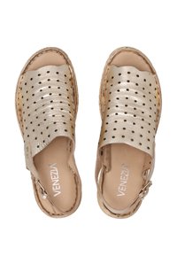 Metalické zlaté boty na slip-on s kulatými perforacemi, texturovaný svršek, hnědá stélka a boční spona pro bezpečné upevnění.