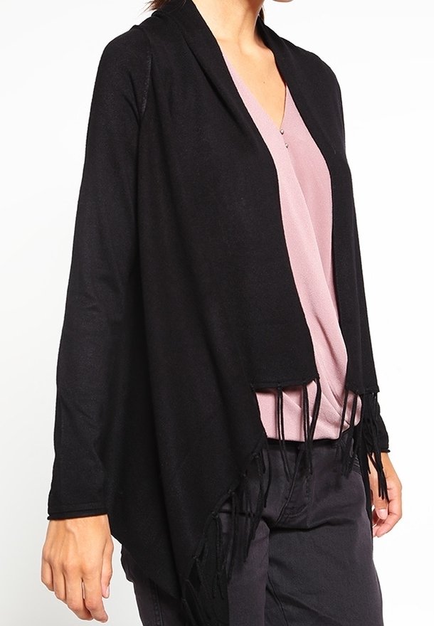 Svart sjal med fransar och öppen framsida, tillverkad av ett mjukt material. Den har en draperad design och är kombinerad med en ljusrosa topp under.