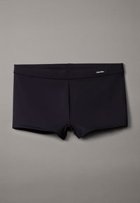 Czarne szorty kąpielowe z gładkiego materiału o dopasowanym kroju. Posiadają elastyczny pas i logo Calvin Klein z przodu.