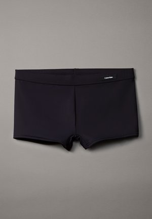 Shorts de bain noirs en tissu lisse avec un design ajusté. Dotés d'une taille élastique et d'un logo Calvin Klein à l'avant.