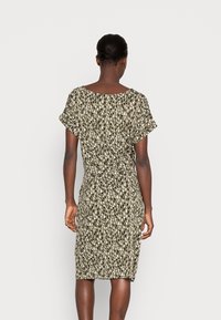 Knielanges Kleid aus olivgrünem Stoff mit schwarz-weißer abstrakter Musterung, kurzen Ärmeln, rundem Ausschnitt und taillierter Silhouette.