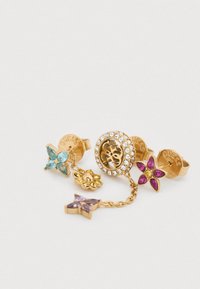 Βραχιόλι με χρυσή απόχρωση και φυλαχτά, διακοσμημένο με λουλουδάτα σχέδια με πολύχρωμες πέτρες: τιρκουάζ, μοβ, κίτρινο και ροζ, με διακοσμήσεις από στρας και λογότυπο.