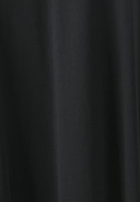 Black cotton fabric with a smooth texture, draped in soft folds, featuring a solid color without patterns or visible hardware.