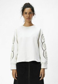 Witte sweatshirt met ronde decoratieve patronen op de mouwen, voorzien van ribgebreide manchetten en een ronde ronde hals. Soepele textuur, ontspannen pasvorm.