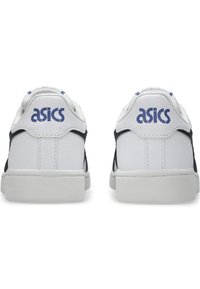 Vita och marinblå sneakers med en texturerad läderfinish, som har blå "ASICS"-logotyp på hälen och en gummisula.