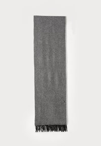 Foulard en noir et gris à motif en chevron, fabriqué en tissu doux, avec des franges aux extrémités. Forme longue et rectangulaire.