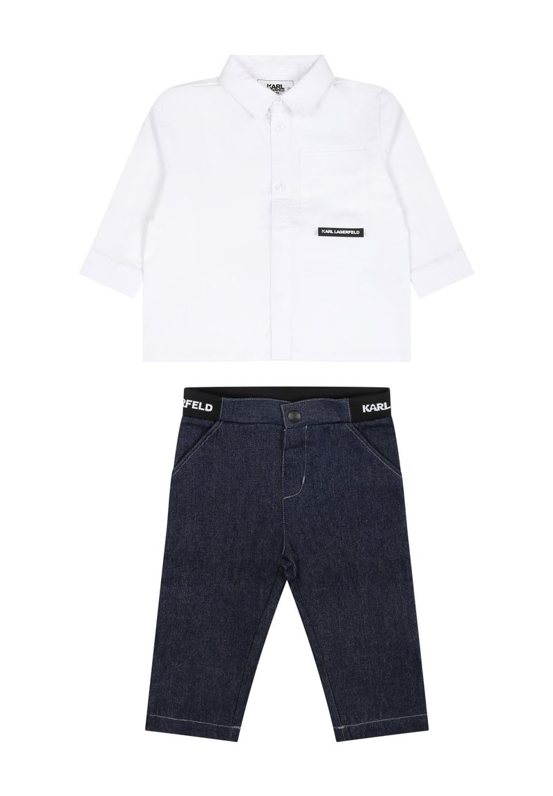 Camicia bianca a maniche lunghe con colletto abbottonato e taschino sul petto. Pantaloni in denim blu scuro con vita elasticizzata e accentuazione del logo.