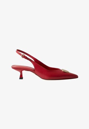 Zapato de tacón bajo slingback de cuero rojo con punta afilada y adorno en forma de corazón dorado en la parte delantera.