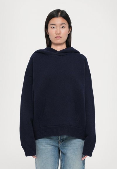 Marineblaues Kapuzensweatshirt mit lockerer Passform, gerippten Bündchen und Saum. Verfügt über zwei Fronttaschen und eine weiche Strickoberfläche.
