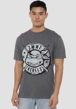 Graues Baumwoll-T-Shirt mit einem großen schwarz-weißen Grafik eines Schildkrötenkopfes und gekreuzten Waffen, mit dem Text "TMNT REBELS".