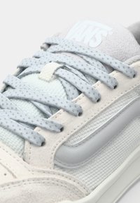 Baskets en suède et mesh, avec des lacets gris clair, un panneau texturé de couleur menthe, et une semelle en caoutchouc blanche.