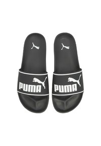 Pair of black Puma slide sandals with white Puma logo and text on the strap, and smaller logo on the footbed.