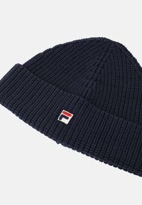 Beanie a maglia blu navy realizzato in tessuto a costine, con risvolto e un piccolo logo ricamato con accenti rossi e bianchi.