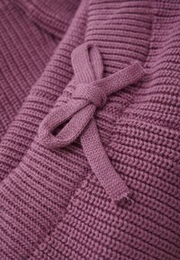 Gestrickter Pullover in sanftem Lavendel mit einem gerippten Muster. Verfügt über ein gebundenes Schleifendetail aus demselben Material, was einen harmonischen Look schafft.