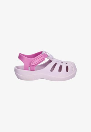 Sandalia lila claro con correa rosa ajustable, diseño de punta abierta con recortes laterales y suela resistente.