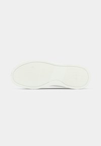 Valge kummist jalanõu tald, millel on tekstureeritud pidurdamismuster, ümardatud servad ja sile keskmine osa, et tagada suurem paindlikkus.