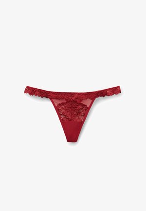 Roter Spitzenstring mit floralem Muster und transparenten Einsätzen, ausgestattet mit gewellten Kanten und einem soliden Stoffrücken für zusätzlichen Komfort.