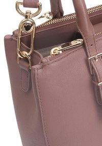 Leren handtas in gedempt mauve met gouden hardware, voorzien van een ritssluiting en een afneembare schouderriem. Glad materiaal en gestructureerde vorm.