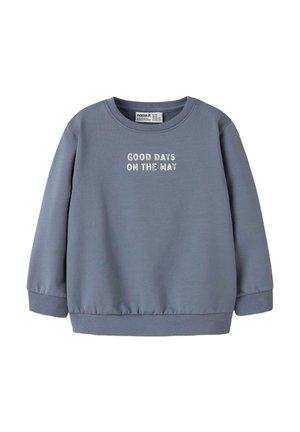 Sweatshirt gris à manches longues, avec des poignets et un ourlet côtelés. Arbore le texte "DES BONS JOURS SONT EN ROUTE" imprimé en blanc sur la poitrine.