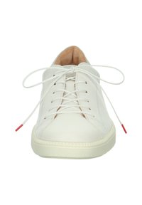 Sneaker in pelle bianca con punta rotonda, lacci piatti e accento rosso sull'estremità dei lacci. Presenta una suola testurizzata e una fodera interna liscia.