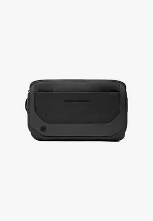 Bolso negro con textura de forma rectangular, con un bolsillo frontal con cremallera y logo en relieve, hecho de materiales duraderos.