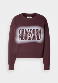 Sweat-shirt court bordeaux en tissu doux, présentant une impression graphique audacieuse avec le texte "NØRGAARD" en noir et blanc. Encolure ronde et poignets.