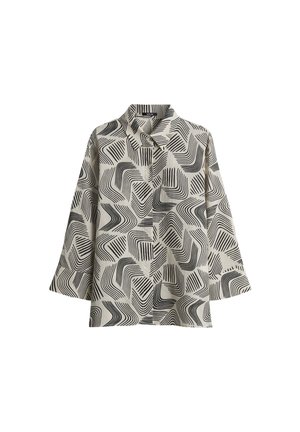 Langarmshirt van een lichtbeige stof met een zwart abstract golvend patroon, knopen aan de voorkant en een puntige kraag.