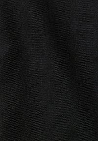 Tissu en denim noir avec texture de sergé diagonal, présentant de fines lignes et de légères variations de teinte.