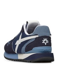 Sneaker blu navy con accenti bianchi e suola azzurra chiara. Materiali in suede testurizzato e mesh con marchio sul tallone e sul lato.