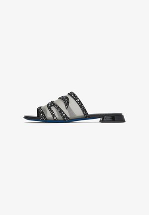 Sandalo modello slide nero con tacco basso a blocchetto, tomaia in mesh trasparente e decorazioni con strass neri a motivi ondulati.