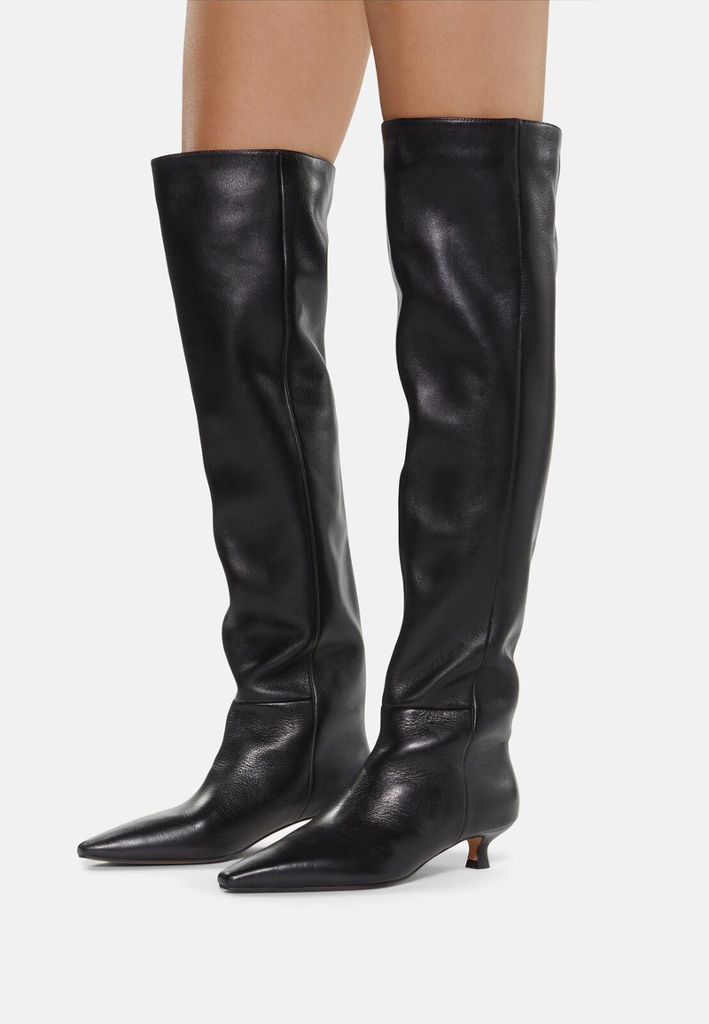 Knee-high black leather boots with a pointed toe and a low angled heel. The upper has a smooth texture and a fitted silhouette.