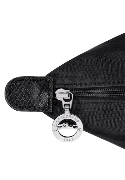 Black fabric zipper with textured leather pull tab and round silver Longchamp zipper charm featuring a horse and the year 1948.