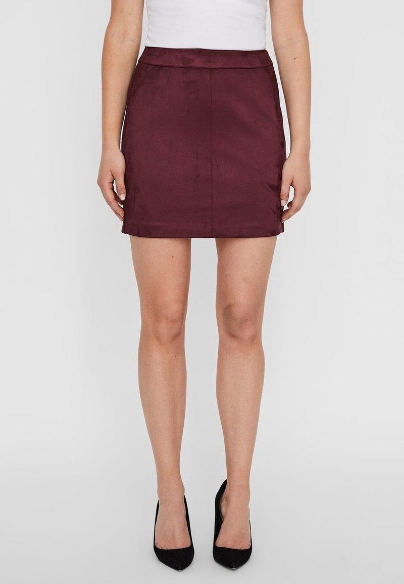Bordowa mini spódnica o gładkiej fakturze, dopasowanym kroju i prostym końcu. Stylizowana z białą bluzką i czarnymi szpilkami.