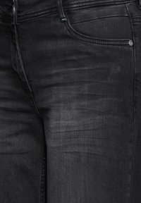 Black denim jeans with a smooth texture, featuring a classic five-pocket design, metal button, and subtle faded areas for added detail.