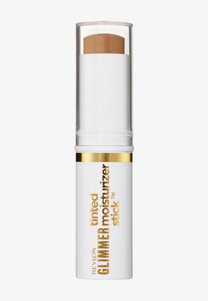Revlon getinte glimmer moisturizer stick met wit en goudkleurig verpakkingsmateriaal en beige vochtinbrengend product zichtbaar aan de bovenkant onder een doorzichtige dop.