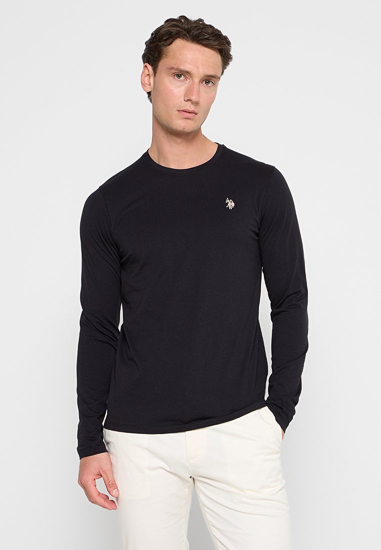 T-shirt noir à manches longues en coton doux avec un col rond, arborant un petit logo brodé sur la partie supérieure gauche de la poitrine.