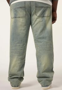 Ljusblå denimjeans, avslappnad passform, rak ben, med två bakfickor med subtila sömnadsdetaljer och en urtvättad yta.