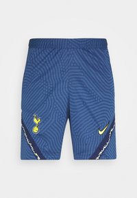 Pantaloni corti blu Nike con un motivo a onde, vita elastica, emblema giallo del Tottenham e un bordo a contrasto con un accento di design distintivo.