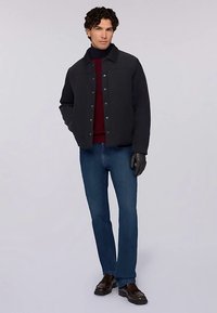 Mörkgrå jacka, röd tröja, blå jeans, svarta handskar och bruna skor. Har knappstängning, krage och slät tygstruktur.