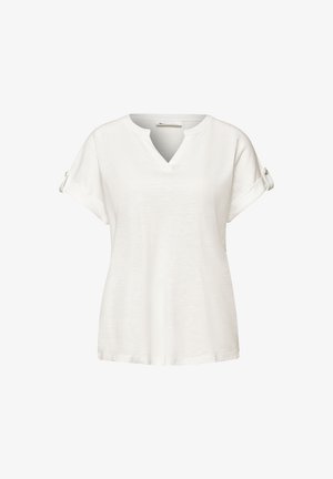 Blouse blanche à manches courtes avec encolure en V et pattes de manches boutonnées, présentée sur un fond uni.