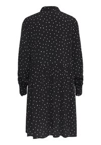 Vestito nero con maniche lunghe, colletto e pois bianchi. Presenta una vita arricciata e polsini con bottoni. Tessuto leggero.