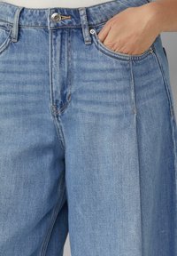 Lichtblauwe denim jeans met een hoge taille, één voork pocket en subtiele wassingdetails. Voorzien van een zilveren knoop en contrasterende stiksels.
