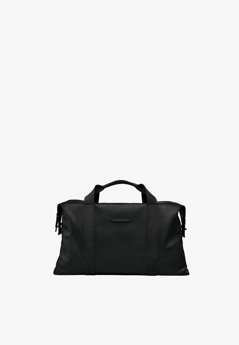 Sac de sport noir en tissu lisse, doté de deux poignées supérieures, d'un accent logo élégant et de poches latérales zippées. Design compact et rectangulaire.