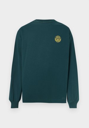 Cămașă cu mâneci lungi din bumbac de culoare verde închis, cu guler rotund, având un emblema galbenă în partea superioară a spatelui. Croi simplu, lejer.