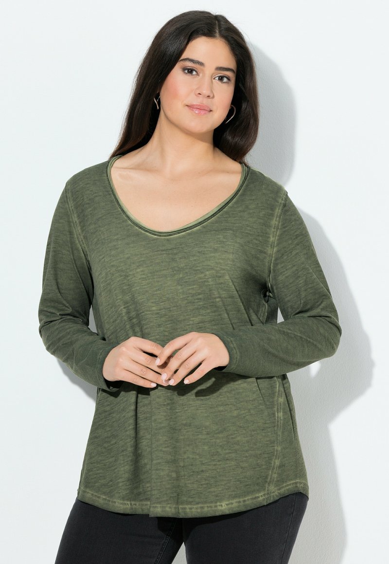 Olijfgroene losvallende blouse met lange mouwen en een brede halslijn, gemaakt van zachte, gestructureerde stof. Gestyled met een afgeronde zoom en zijnaden.