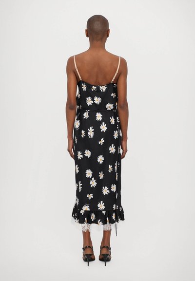 Robe noire à fleurs avec des marguerites blanches, bretelles spaghetti, ourlet volanté, bord en dentelle et coupe ajustée.