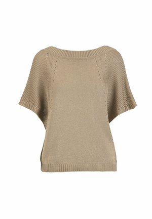 Kobieta w beżowej dzianinowej bluzce z pelerynowymi rękawami, brązowe szerokie spodnie w prążki, wielowarstwowe naszyjniki z koralików, bransoletki, trzyma brązową torebkę z zamszu.