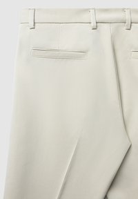 Helle beige Hose aus einem glatten, strukturierten Stoff, mit flachem Vorderteil, Hintertaschen und Gürtelschlaufen. Schlichtes und maßgeschneidertes Design.