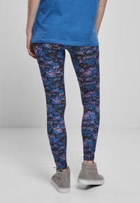 Leggings u digitalnom kamuflažnom uzorku s nijansama plave, ljubičaste i crne. Mekana, elastična tkanina s uskim krojem.