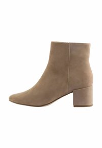 Stivale alla caviglia beige in suede, con punta affusolata e tacco quadrato spesso per garantire stabilità. Texture liscia con un design minimalista.